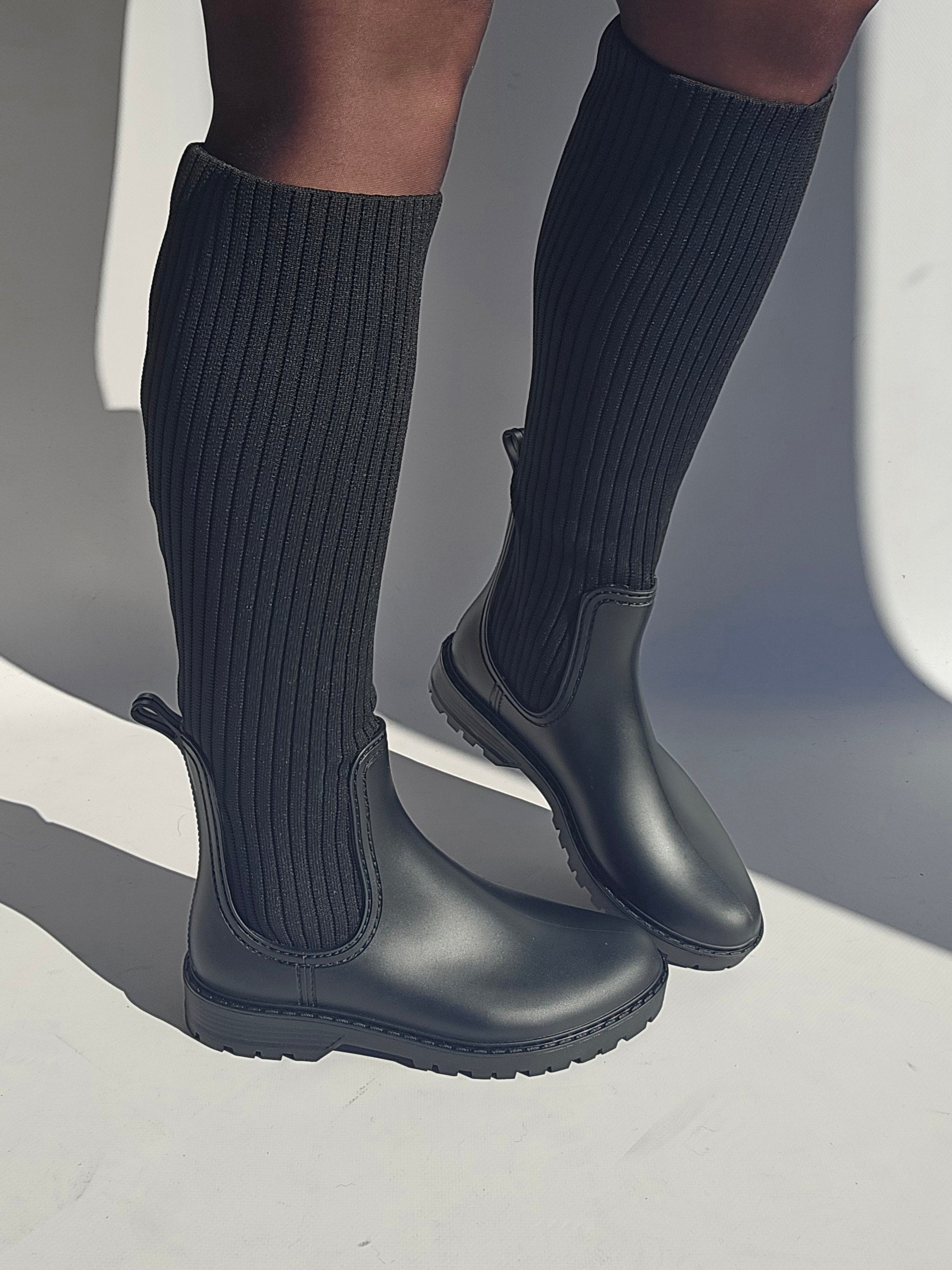 Bottes de pluie noires en style chaussette, alliant fonctionnalité et mode pour des promenades sous la pluie